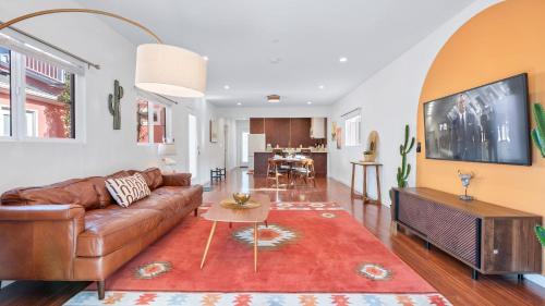 a living room with a brown couch and a red rug at Southwest by AvantStay Heart of Hollywood Remodeled 1920s Bungalow in Los Angeles
