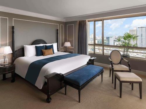 a bedroom with a large bed and a large window at Sofitel Saigon Plaza in Ho Chi Minh City