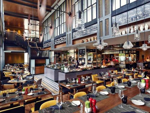 a restaurant with tables and chairs and a bar at Sofitel Saigon Plaza in Ho Chi Minh City