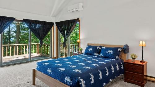 a bedroom with a blue bed and a balcony at Marina Village by AvantStay Walk to Lake Marina Balcony Patio in Greentown