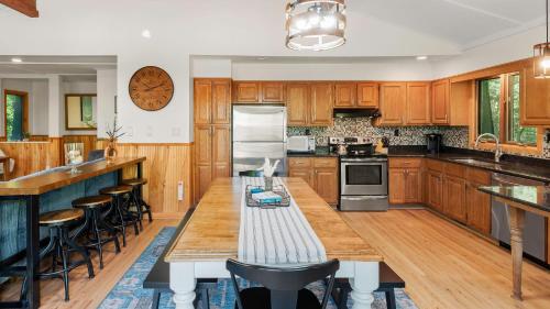a kitchen with wooden cabinets and a large wooden table at Summit Shores Tranquil Escape Designed for Groups w Fire Pit Game Room in Lake Harmony