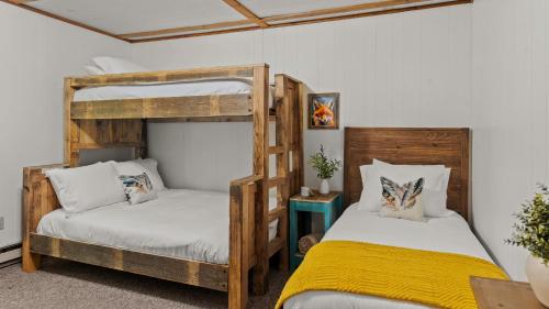 a bedroom with two bunk beds and a yellow blanket at Summit Shores Tranquil Escape Designed for Groups w Fire Pit Game Room in Lake Harmony