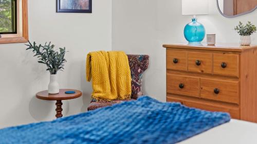 a bedroom with a blue blanket and a chair at Summit Shores Tranquil Escape Designed for Groups w Fire Pit Game Room in Lake Harmony
