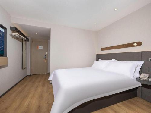a large white bed in a hotel room at Jinjiang Inn Shenzhen Airport in Shenzhen