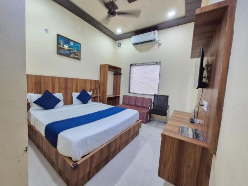 Un dormitorio con una cama, un sofá y un televisor. en Hotel RK Residency Near Prem Mandir, en Vrindāvan