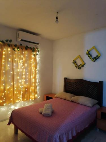 a bedroom with a bed and a window with christmas lights at Casa Ambar 2 recamaras,aire acondicionado y factura in Nogueras