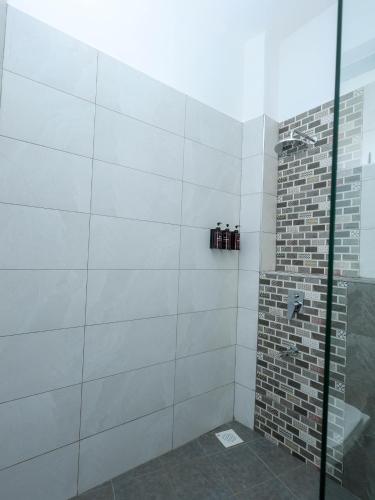 a bathroom with a shower with a glass door at Baobab Waves in Mombasa