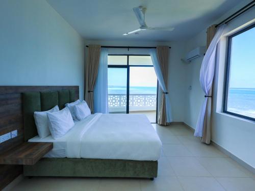 a bedroom with a bed with a view of the ocean at Baobab Waves in Mombasa