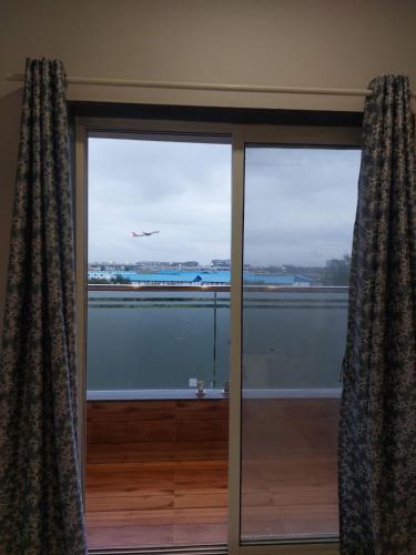 a large glass window with a view of an airplane at Azura Vista by Alt Acco in Pune