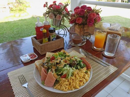 a table with a plate of food on a table at Charisma Resort in Ratchaburi