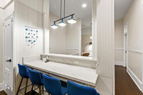 een badkamer met een wastafelmeubel, blauwe stoelen en een spiegel bij Beach House Fun! Sleeps the Whole Crew in Galveston