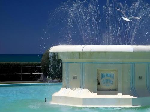 a person in the water in a pool with a fountain at Stables Lodge Backpackers in Napier