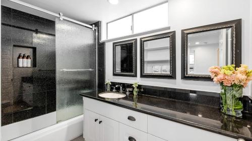 a bathroom with a sink and a shower at Shelly by AvantStay Steps to the Beach Deck w Ocean Views 5BDR in Newport Beach