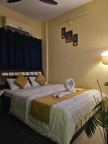 Un dormitorio con una cama con una toalla encima. en Solitude Stays, en Pune
