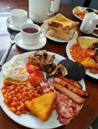 a plate of breakfast food with eggs bacon beans and toast at Elegant homes , KENYA in Nairobi