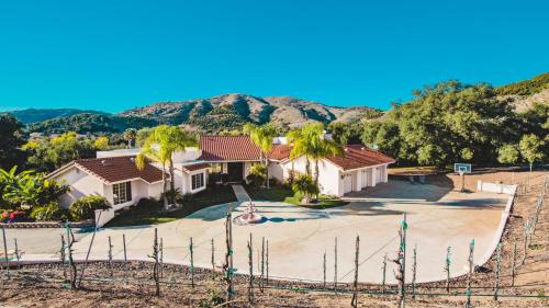 an aerial view of a house with palm trees at Grapevine by AvantStay Secluded 5BR Villa 4 Acres of Vineyards Avo Groves in Temecula