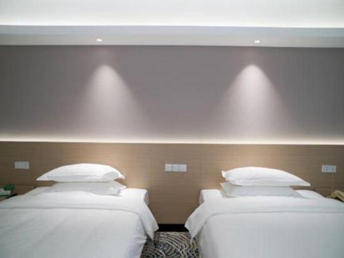 a row of three beds in a room at Grand Nest Hotel (Tang Jia Wan Beach) in Zhuhai