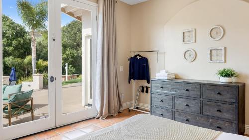 a bedroom with a dresser and a large mirror at Grapevine by AvantStay Secluded 5BR Villa 4 Acres of Vineyards Avo Groves in Temecula