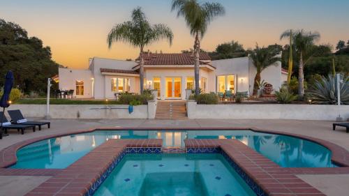 a house with a swimming pool in front of a house at Grapevine by AvantStay Secluded 5BR Villa 4 Acres of Vineyards Avo Groves in Temecula