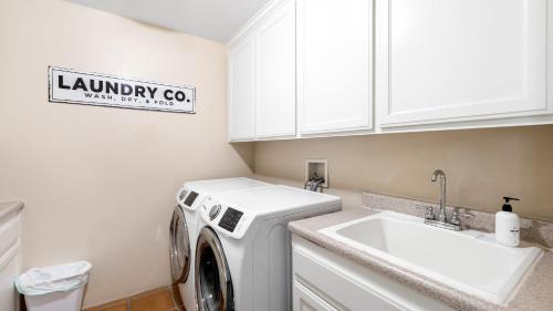 a laundry room with a washing machine and a sink at Grapevine by AvantStay Secluded 5BR Villa 4 Acres of Vineyards Avo Groves in Temecula