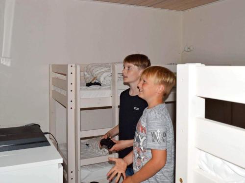 two young boys standing next to a bunk bed at 8 person holiday home in Sydals-By Traum in Skovbyballe