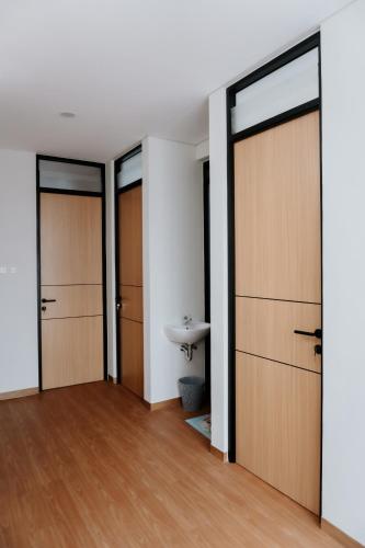 a bathroom with wooden doors and a sink at Villa Caldera C6 Batu in Tlekung