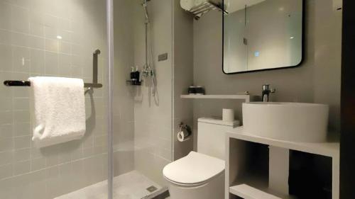 a bathroom with a toilet and a sink and a shower at Magnotel Shanghai Henglong Plaza in Shanghai