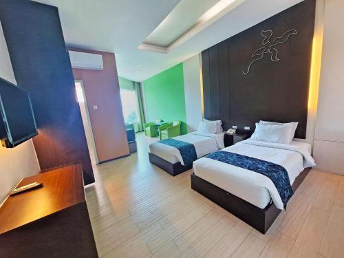 Una cama o camas en una habitación de Hotel New Puri Garden