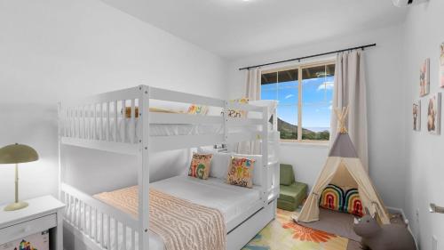 a white bedroom with a bunk bed and a window at Lealea by AvantStay Ocean Mountain Views in Waianae