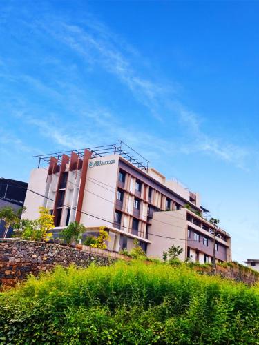 een gebouw op een heuvel naast een muur bij Parays Fernwoods in Mannārakkāt