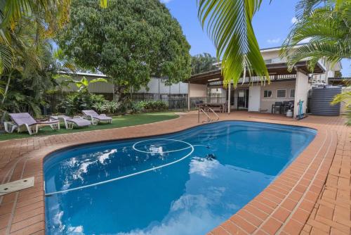 a blue swimming pool with a basketball hoop in a yard at Bongaree Beach House with Pool in Bongaree