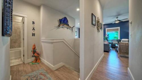 a hallway of a home with a staircase and a living room at Pool Walk to Old Town Eateries Nightlife Shopping Rock N Reelby AvantStay in Port Aransas