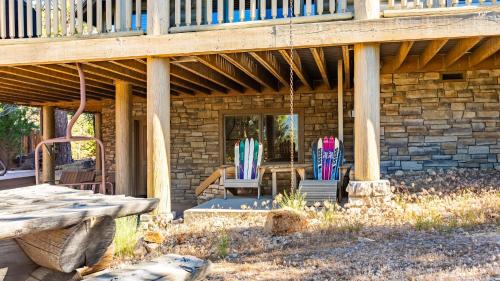 two chairs and a table on a patio under a deck at Hot Tub Game Room Large Deck w Incredible View Penticton Lodge by AvantStay in Big Bear Lake
