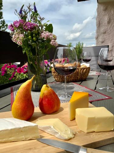 a table with cheese and a glass of wine and pears at Hubertushof in Jungholz