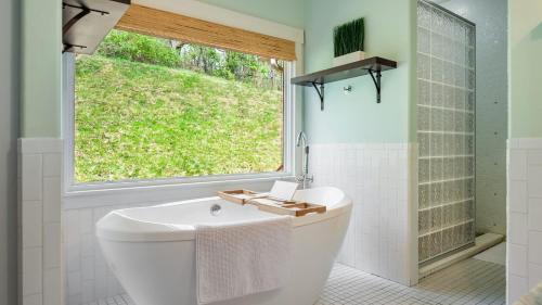 a bathroom with a white tub and a window at Silver Spoon by AvantStay Hot Tub Views Billiards Group Retreat in Leicester