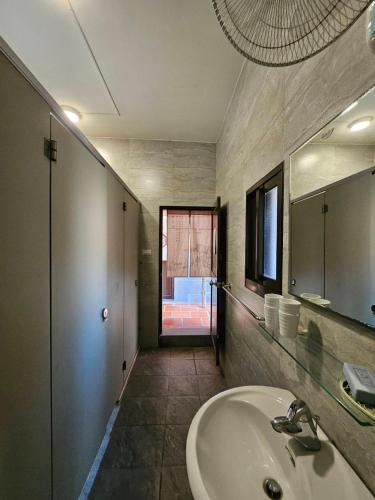 a bathroom with a sink and a mirror at Blue Mountain Inn in Jinning
