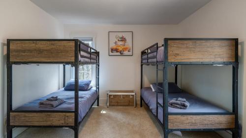 a bedroom with two bunk beds with blue sheets at Silver Spoon by AvantStay Hot Tub Views Billiards Group Retreat in Leicester
