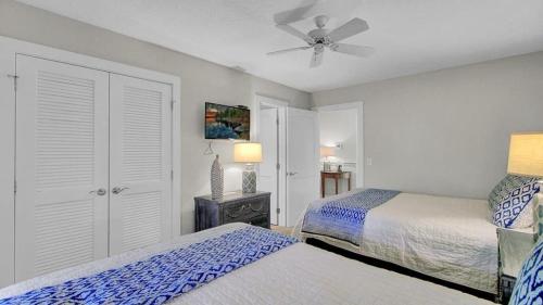 Un dormitorio con dos camas y un ventilador de techo. en 19 Oyster Row by AvantStay Lakefront Home w Golf Course Views, en Isle of Palms