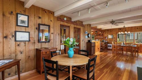 a dining room with a vase of flowers on a table at The Pilot House by AvantStay Stunning Home Right On Arch Cape Beach in Arch Cape
