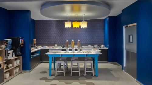 a kitchen with blue walls and a blue table with stools at One Ciudad de Mexico Patriotismo in Mexico City