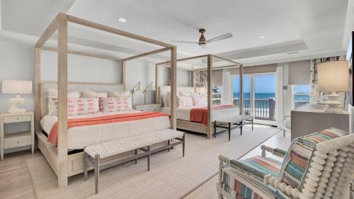 una camera da letto con un letto e un balcone con vista sull'oceano di 114 Ocean Boulevard by AvantStay Beachfront Infinity Pool Basketball Court Recently Renovated a Sullivan's Island