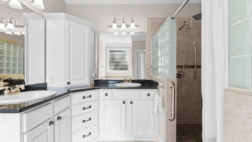 a white bathroom with a sink and a shower at Sunset Pointe by AvantStay Waterfront Beach Fire Pit Sleeps 14 5BDR 4BA in Terrell