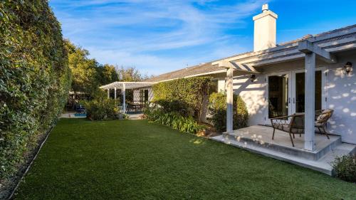 a house with a lawn and a chair on a porch at Goleta Getaway by AvantStay Private Backyard 1.5mi to the Beach in Santa Barbara