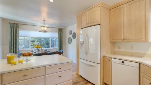 a kitchen with wooden cabinets and a white refrigerator at Goleta Getaway by AvantStay Private Backyard 1.5mi to the Beach in Santa Barbara