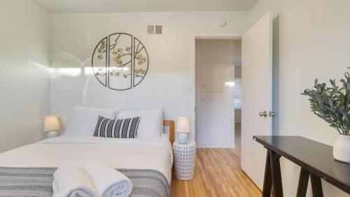 a white bedroom with a bed and a table at Goleta Getaway by AvantStay Private Backyard 1.5mi to the Beach in Santa Barbara