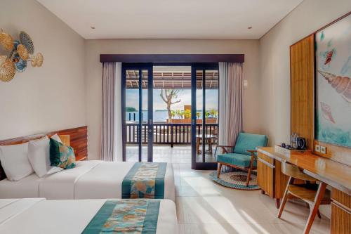a hotel room with a bed and a desk and a balcony at Sepa Island Resort in Pulau Tondan Barat