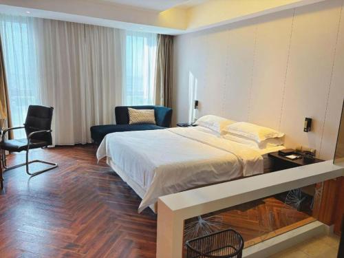 a bedroom with a bed and a desk and a chair at Jinjiang Metropolo Hotel - Taizhou Wanda Plaza in Taizhou