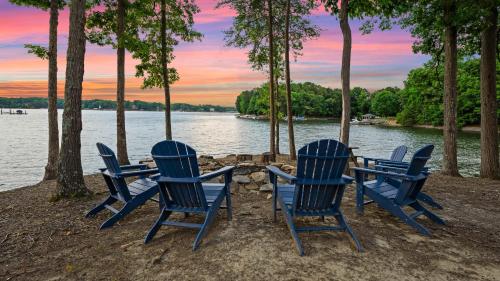 a group of blue chairs sitting around a table by the water at Paradise Pointe by AvantStay Lakefront Views Playset in Lake Norman of Catawba