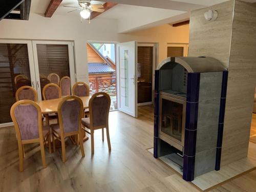 a dining room with a fireplace and a table and chairs at Paradise of Bogë Naturhaus in den Bergen von Peja in Peje