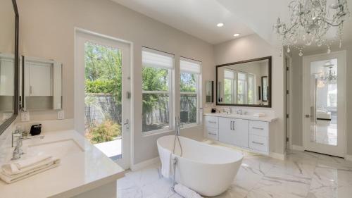 a large bathroom with a tub and a large window at Villa Valentina by AvantStay Pool Hot Tub Views Luxury Design in Palm Springs
